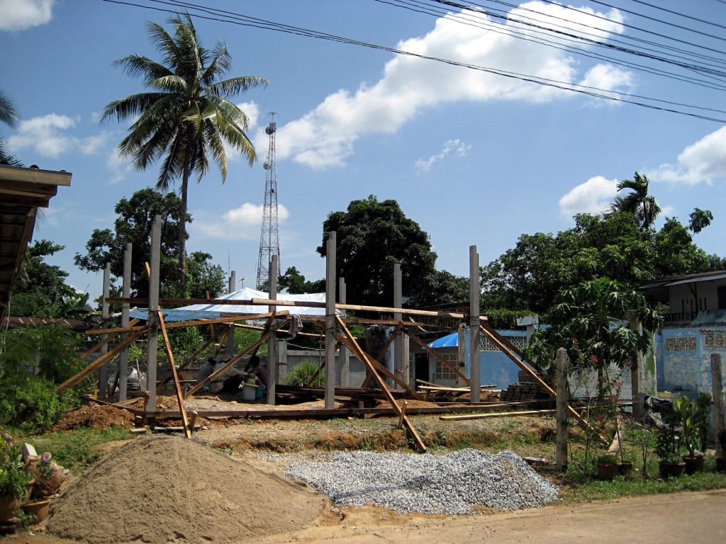 Workers assembling a prefabricated modular house section on a construction site