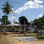 Workers assembling a prefabricated modular house section on a construction site